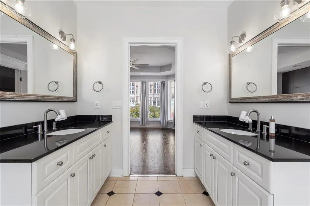 Full bath featuring two vanities, light tile patterned floors, and a ceiling fan Full bath featuring two vanities, light tile patterned floors, and a ceiling fan