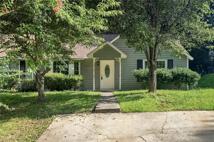 Light green siding exterior featuring a covered entry porch with a white oval-lite door
