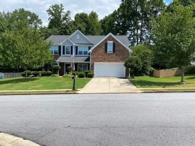 Brick and siding exterior with a gabled roofline, two-car garage, and established landscaping