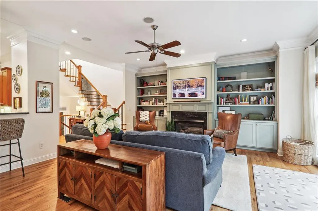 Living room with a premium fireplace, ornamental molding, and light hardwood / wood-style flooring