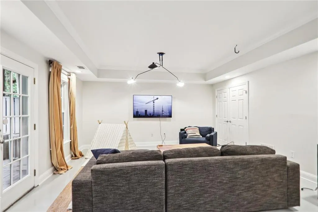 Living room featuring a raised ceiling and ornamental molding