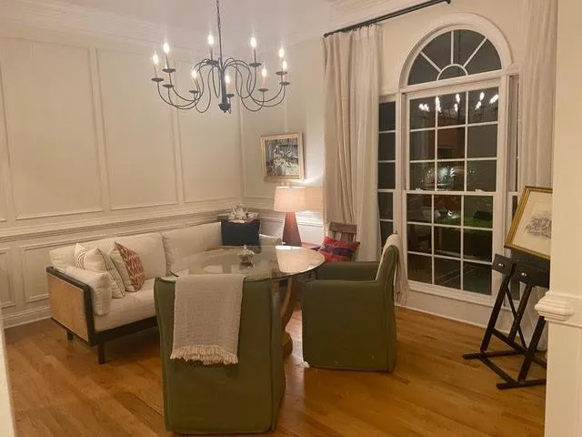 Dining area featuring hardwood / wood-style floors, ornamental molding, and an inviting chandelier