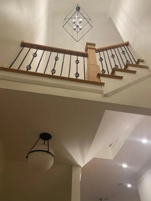 Stairs featuring ornamental molding and a chandelier