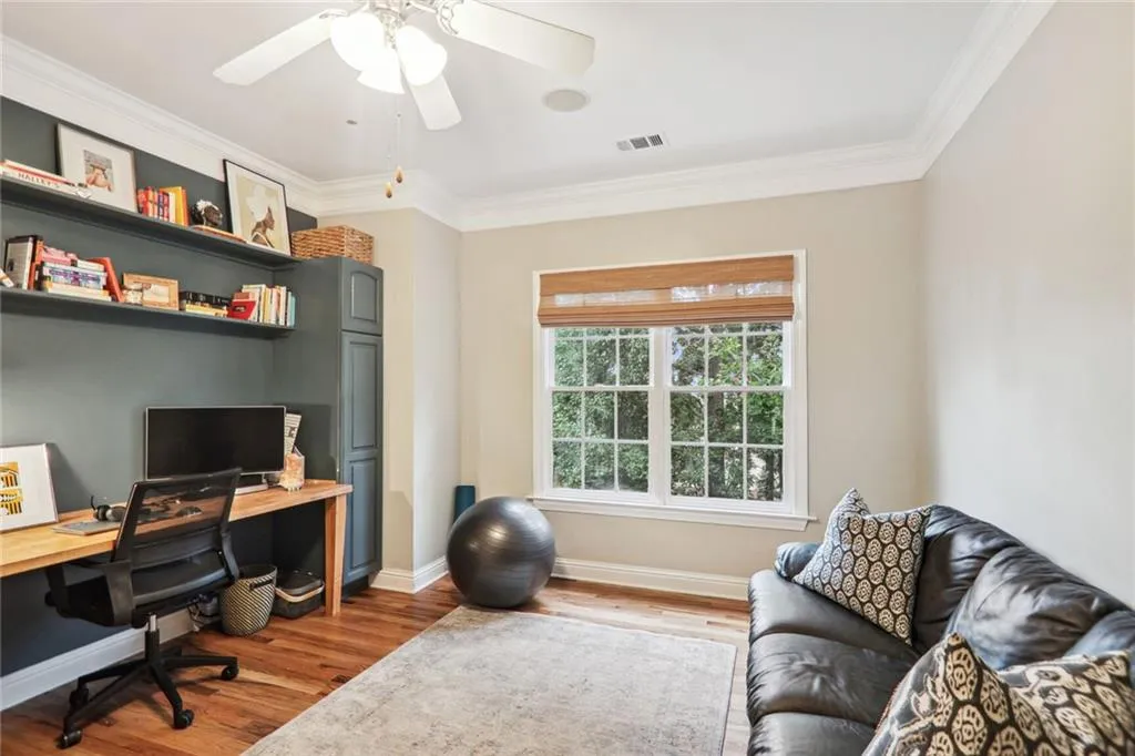 Office area with wood-type flooring, crown molding, and ceiling fan