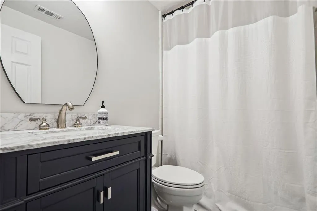 Bathroom with walk in shower, vanity, and toilet