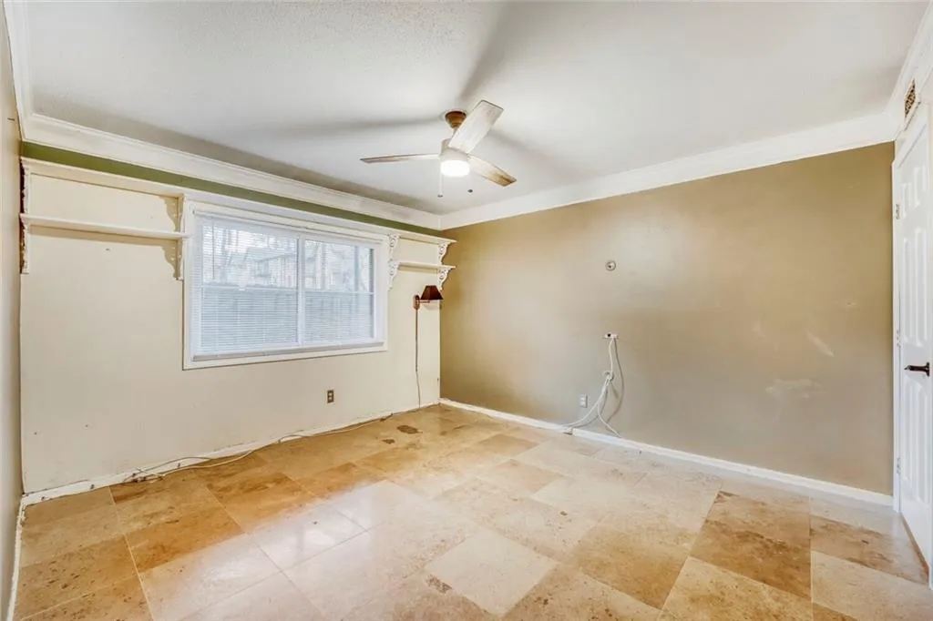 Spare room featuring a ceiling fan and crown molding