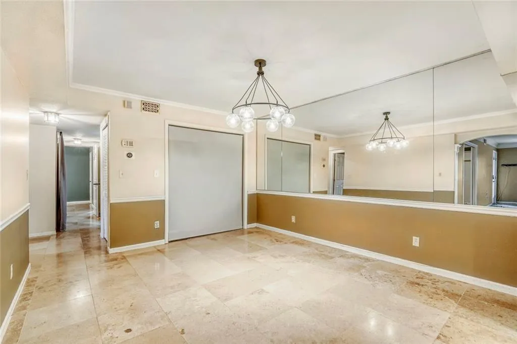 Unfurnished dining area featuring crown molding, a chandelier, and arched walkways