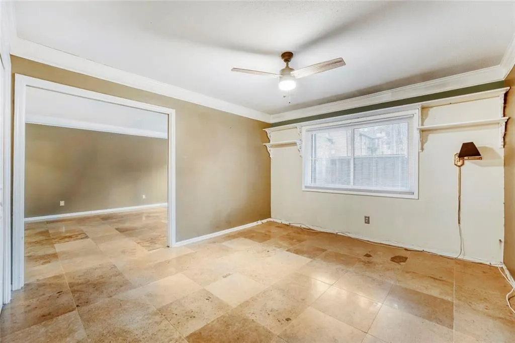 Spare room with ornamental molding and a ceiling fan