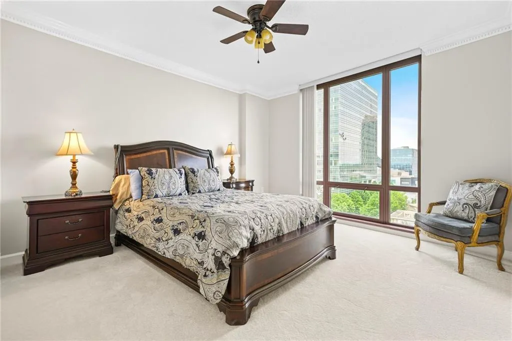 Bedroom featuring light carpet, ornamental molding, ceiling fan, and baseboards