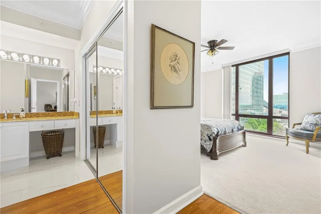 Bedroom with crown molding, a sink, baseboards, and ensuite bath