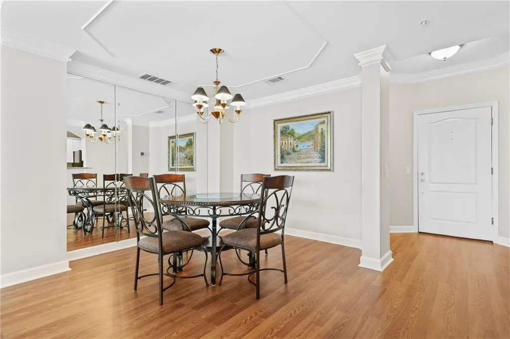 Dining area featuring a chandelier, ornamental molding, light wood-style floors, and baseboards