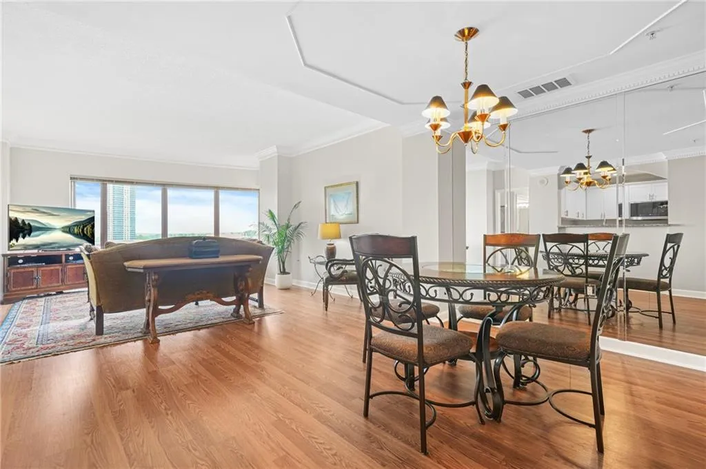 Dining space featuring a chandelier, ornamental molding, baseboards, and light wood-style flooring