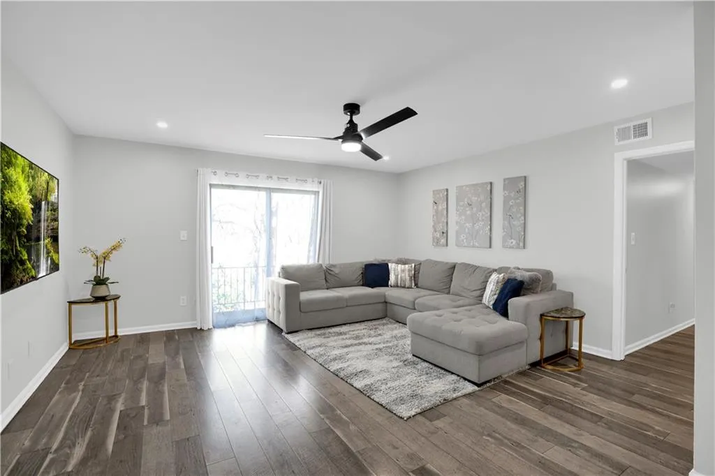 Living area featuring a ceiling fan, recessed lighting, and dark wood finished floors