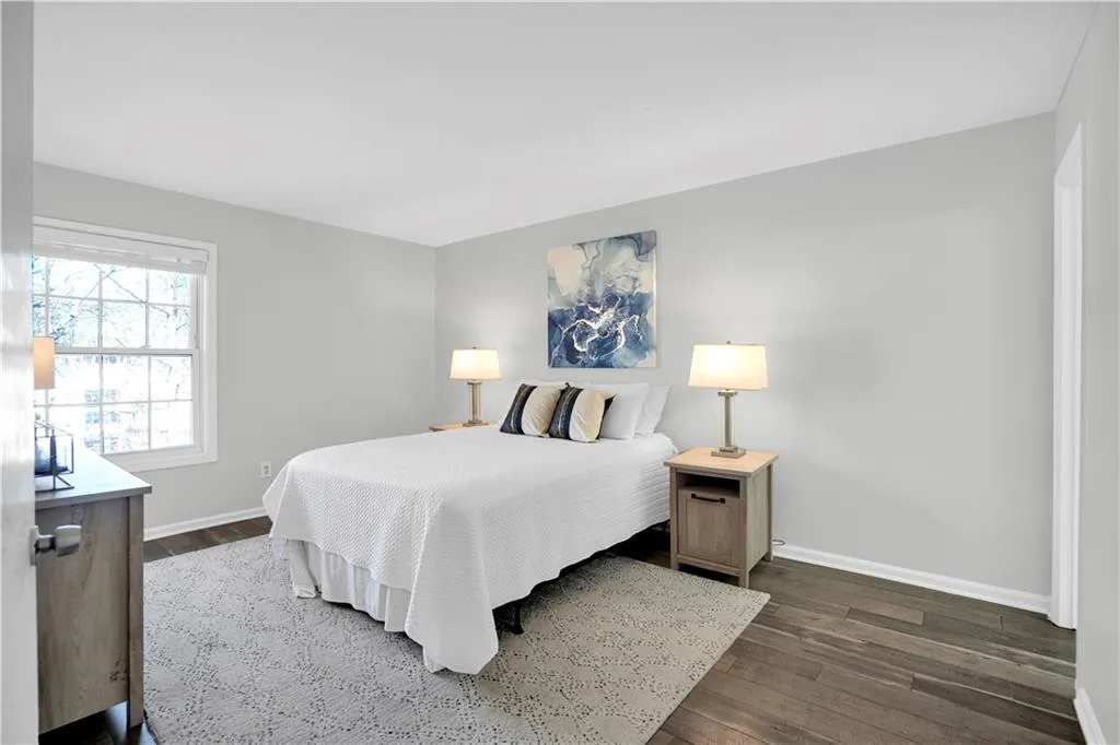 Bedroom featuring dark wood-style flooring and baseboards