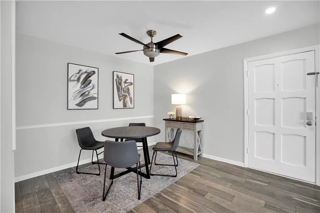 Dining area with a ceiling fan and dark wood-type flooring