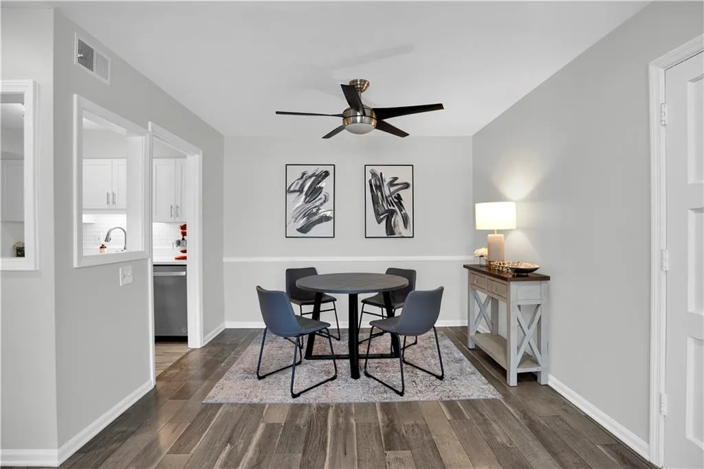 Dining space with a ceiling fan and dark wood-style flooring