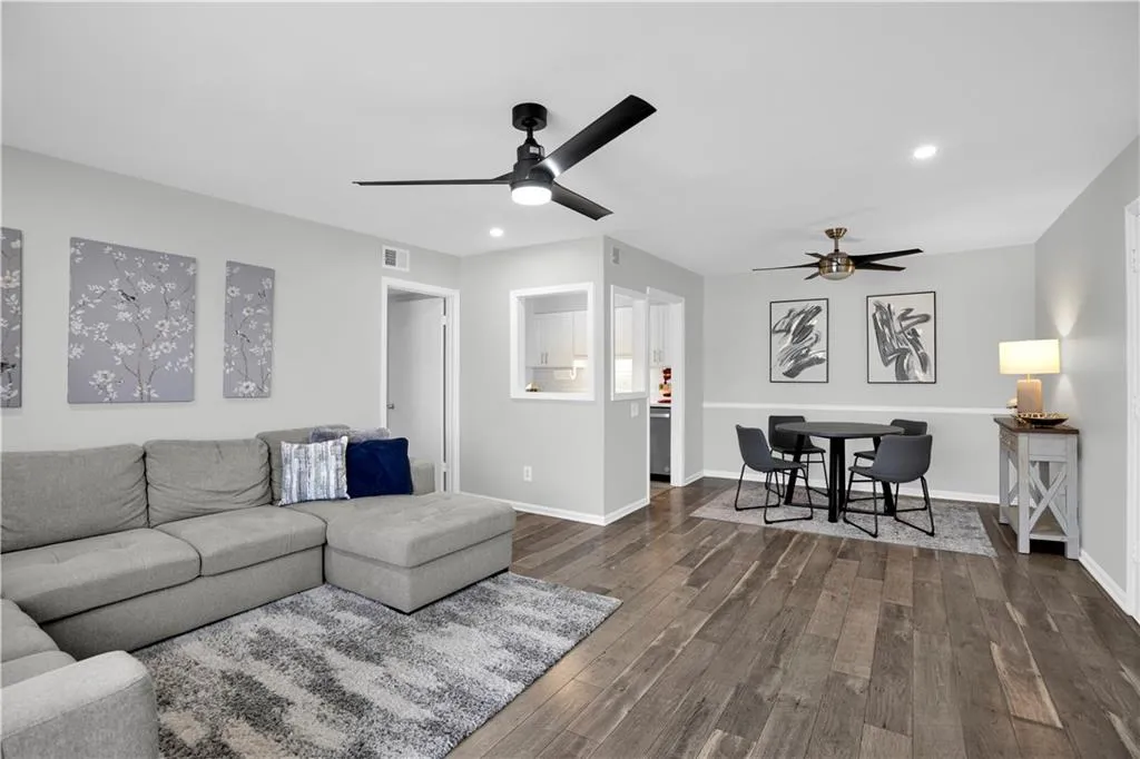 Living room featuring dark wood finished floors, recessed lighting, and a ceiling fan
