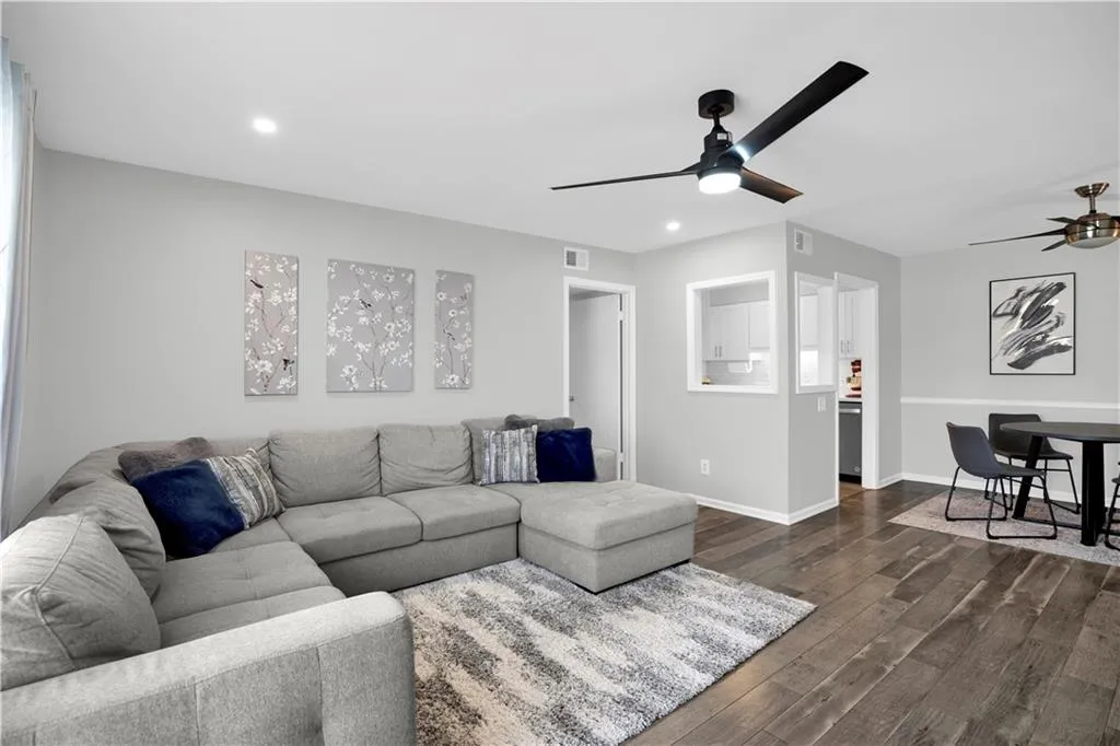Living room with dark wood finished floors, ceiling fan, and recessed lighting