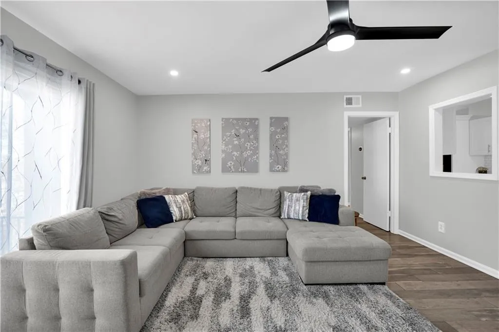 Living room with wood finished floors, a ceiling fan, and recessed lighting
