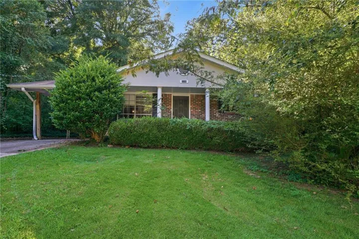Front exterior with a covered carport, brick facade accents, and a covered porch