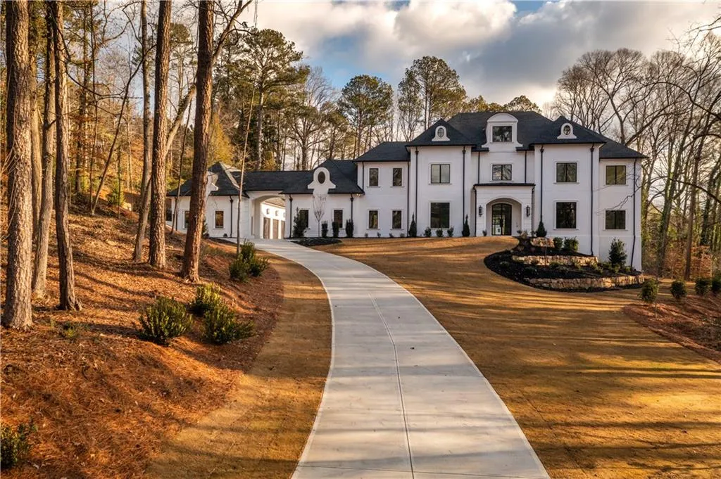 French country style house with stucco siding and driveway