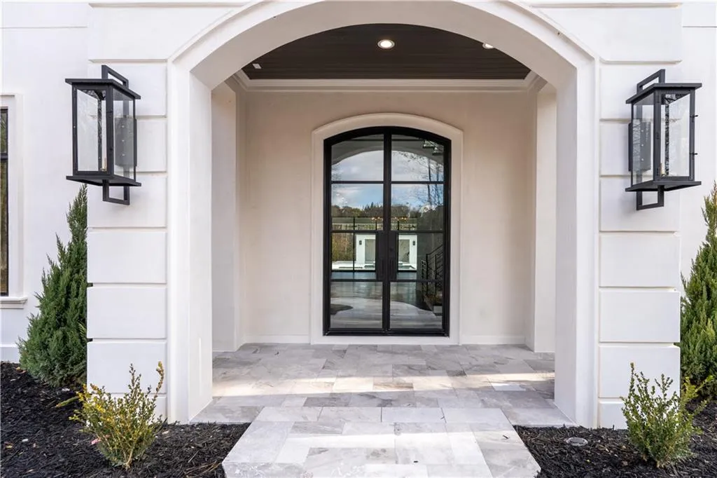 Property entrance featuring stucco siding and french doors