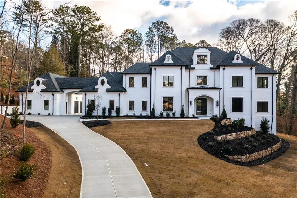 French country home featuring stucco siding and curved driveway