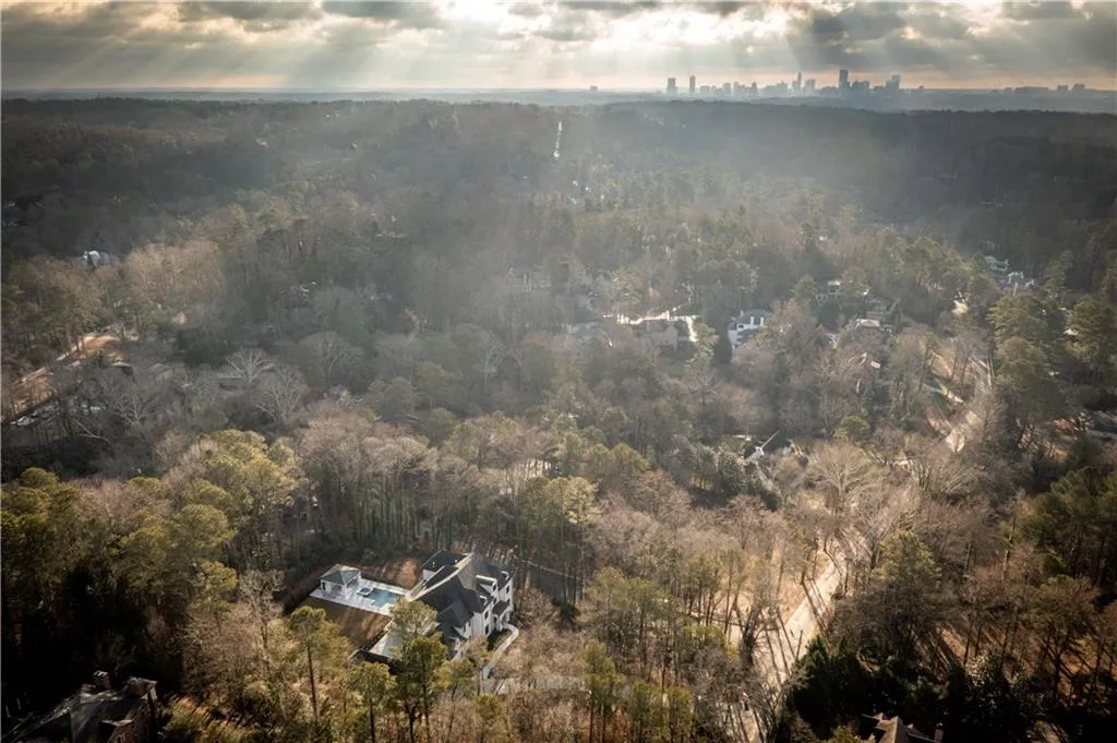 Aerial view of property and surrounding area featuring a heavily wooded area