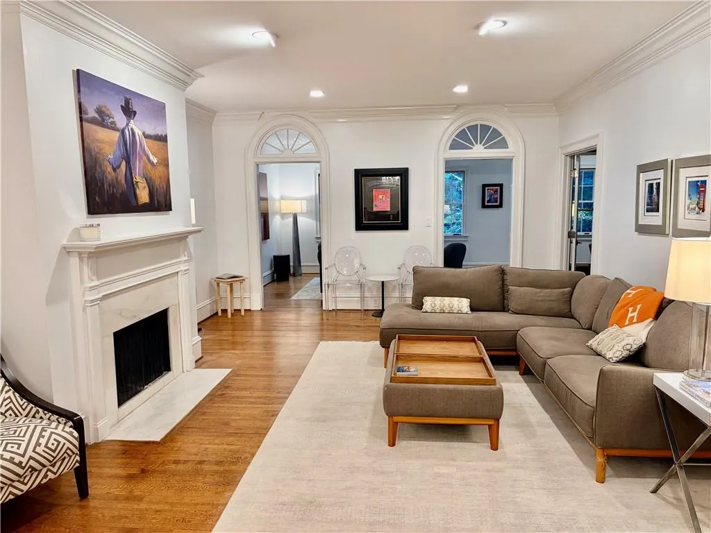 Hardwood flooring throughout, featuring a fireplace with a stone surround and hearth