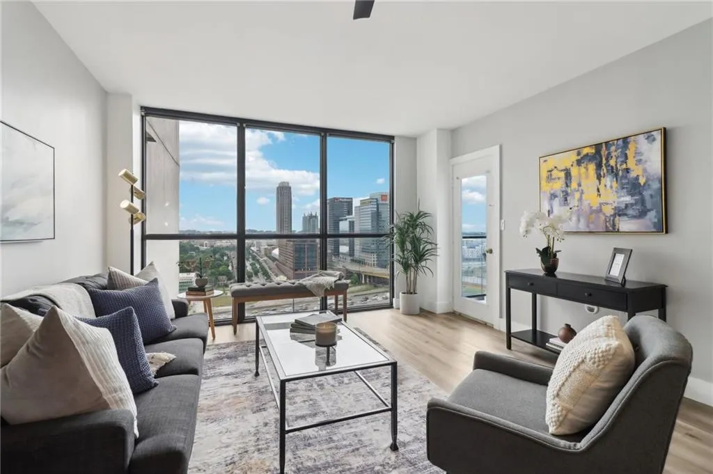 Living area with expansive windows, wood finished floors, and a view of city