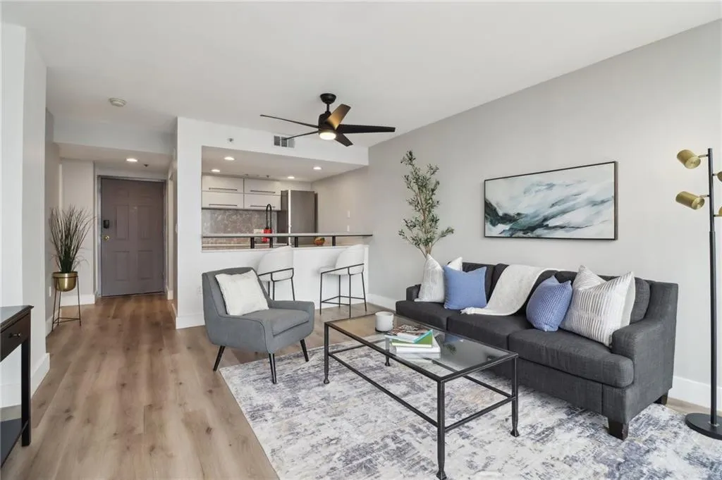 Living room featuring light wood finished floors, a ceiling fan, baseboards, and recessed lighting