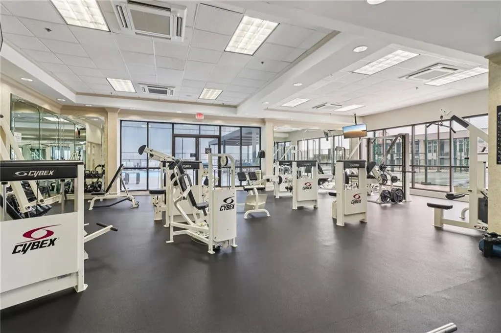 Exercise room with a paneled ceiling and a raised ceiling