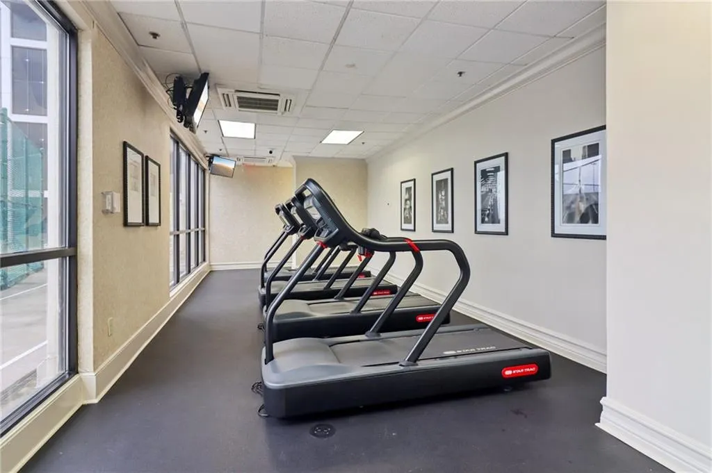 Exercise room featuring a drop ceiling, baseboards, and plenty of natural light