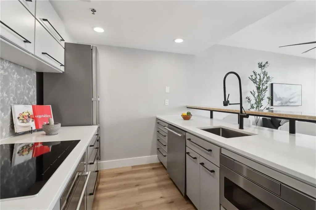 Kitchen with a sink, stainless steel appliances, light wood-style floors, light countertops, and recessed lighting