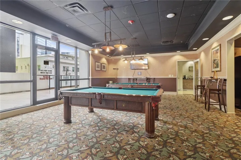 Playroom featuring crown molding, carpet flooring, billiards table, wainscoting, and a raised ceiling