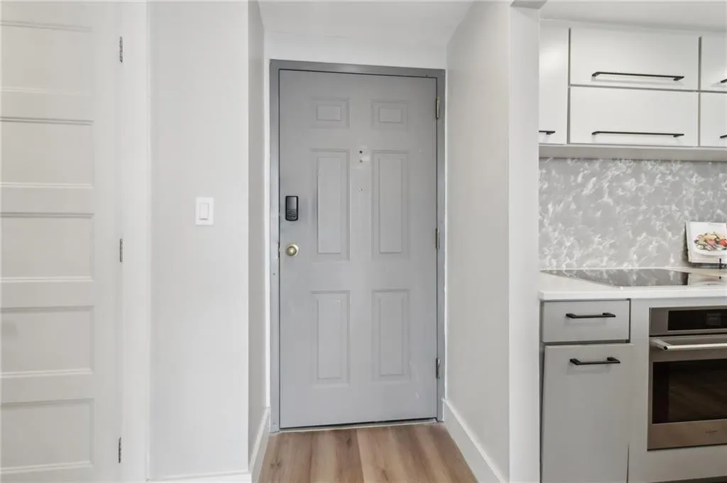 Doorway featuring light wood-type flooring and baseboards