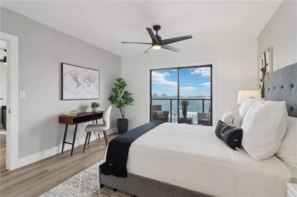 Bedroom featuring access to exterior, wood finished floors, baseboards, and a ceiling fan