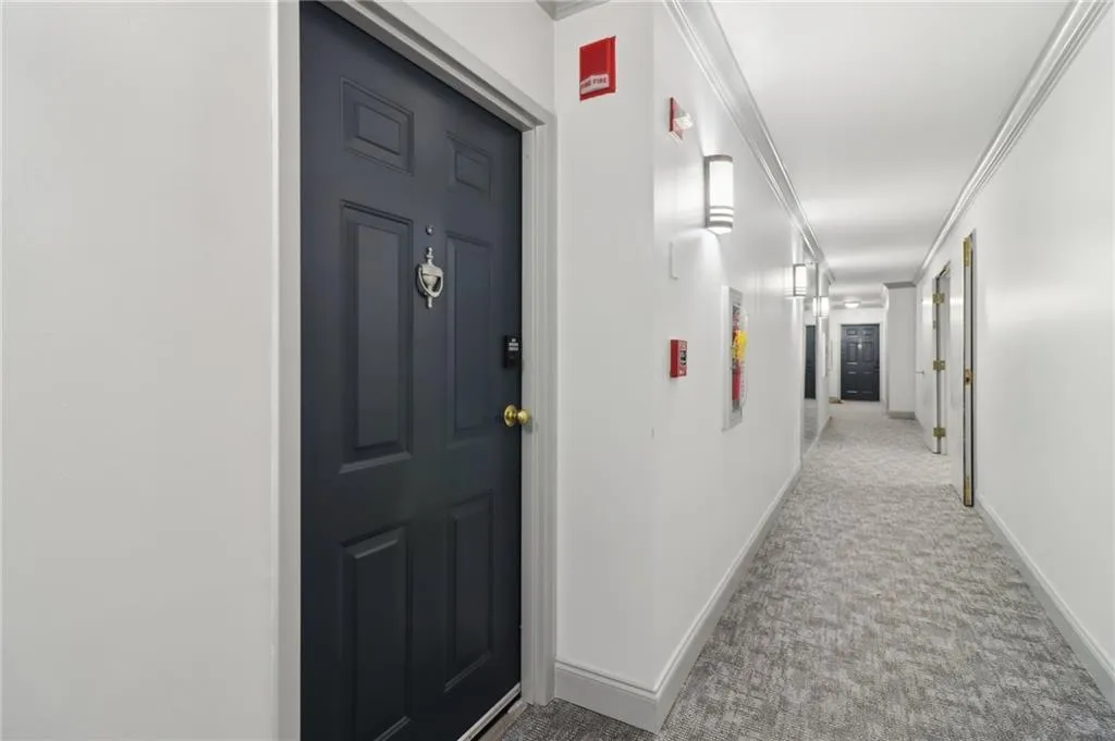 Hallway with carpet floors, baseboards, and ornamental molding