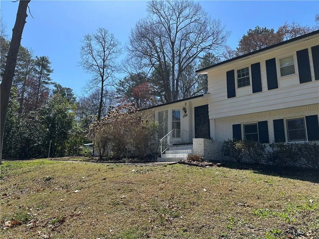 Split level home featuring brick siding and a front yard