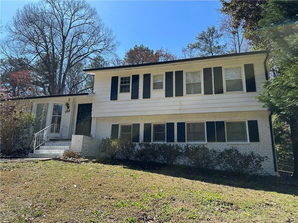 Tri-level home with brick siding and a front lawn
