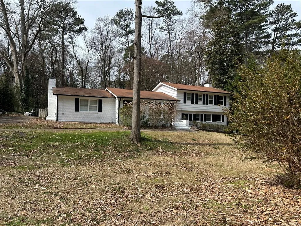 View of front of property featuring a front yard and a chimney