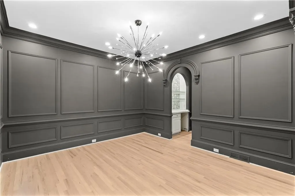 Spare room featuring arched walkways, a decorative wall, recessed lighting, a chandelier, and light wood finished floors