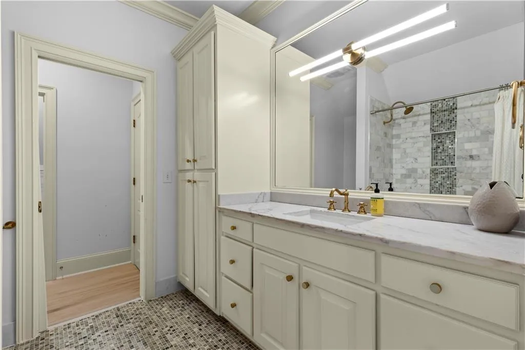 Full bath with vanity, a tile shower, and light tile patterned floors