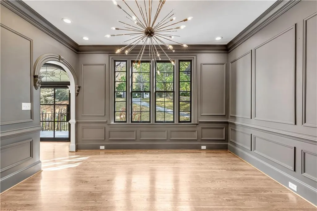 Unfurnished dining area with a decorative wall, a chandelier, light wood-style flooring, ornamental molding, and recessed lighting