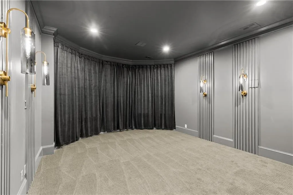 Home theater room featuring ornamental molding, light carpet, and recessed lighting