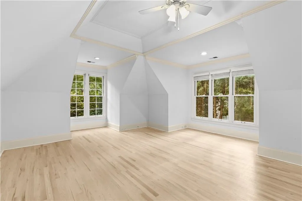Additional living space with light wood-style flooring, healthy amount of natural light, ceiling fan, vaulted ceiling, and recessed lighting