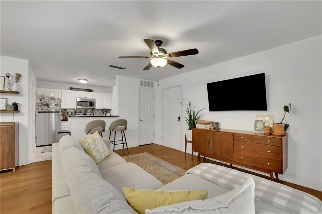 Living room with light hardwood / wood-style flooring and ceiling fan