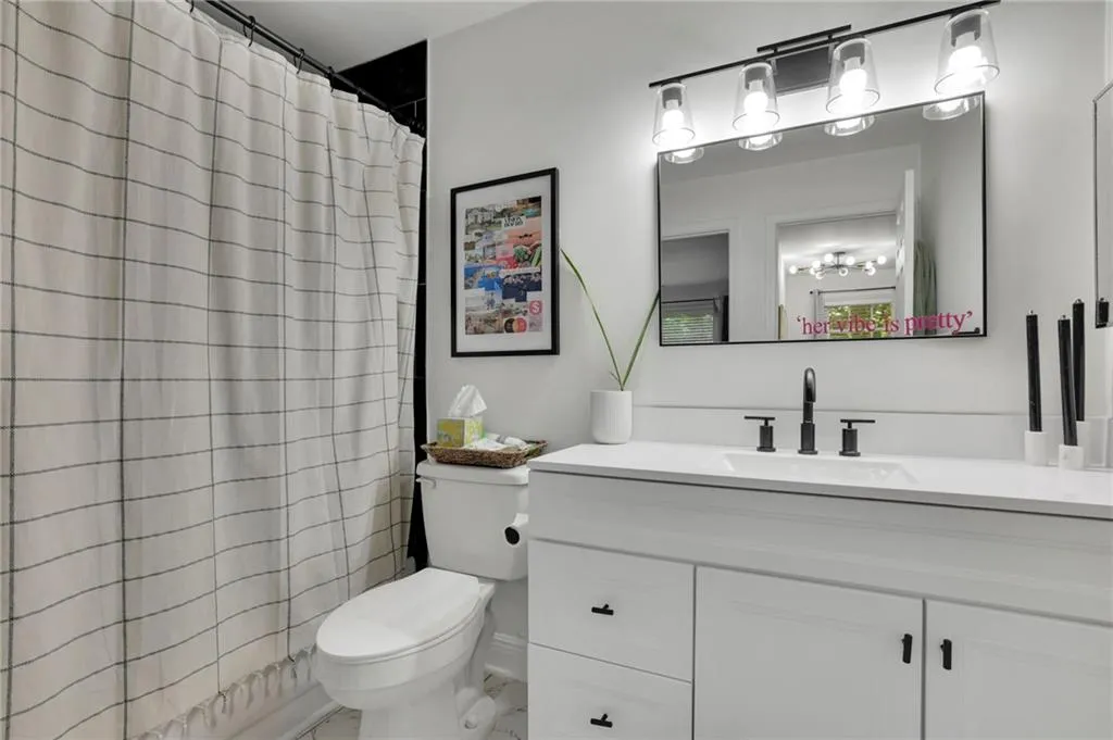 Bathroom featuring vanity, a shower with shower curtain, and toilet