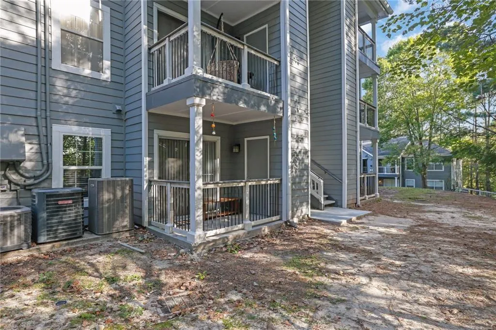 View of side of property featuring central AC and a balcony