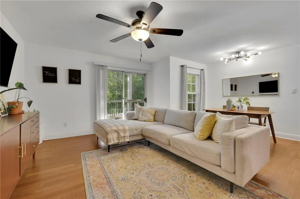 Living room with light hardwood / wood-style flooring and ceiling fan